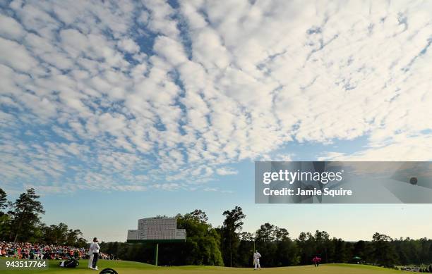 General view is seen as Patrick Reed of the United States lines up a putt on the 18th green as Rory McIlroy of Northern Ireland looks on during the...