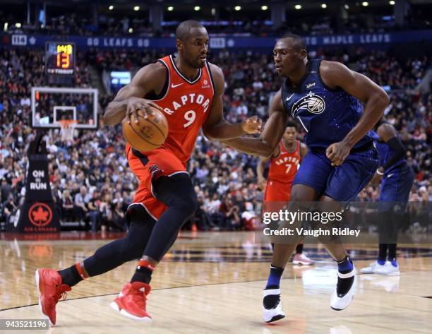 Serge Ibaka of the Toronto Raptors dribbles the ball as Bismack Biyombo of the Orlando Magic defends during the second half of an NBA game at Air...