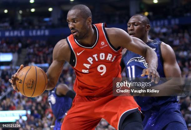 Serge Ibaka of the Toronto Raptors dribbles the ball as Bismack Biyombo of the Orlando Magic defends during the second half of an NBA game at Air...