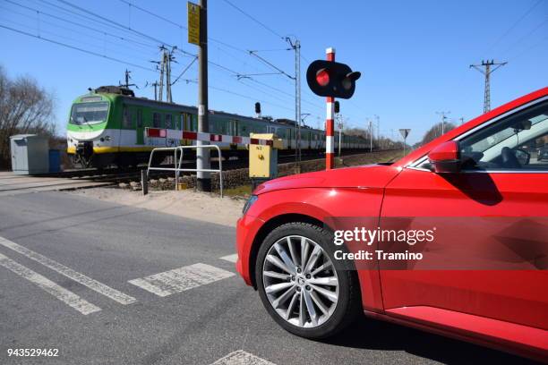 modern car waiting on the railroad crossing - car red light stock pictures, royalty-free photos & images