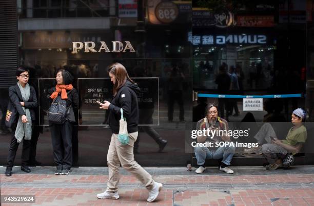 Pedestrians walks past the Italian luxury fashion company Prada store in Causeway Bay, Hong Kong.