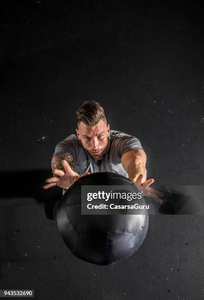 hombre adulto, hacer ejercicio de resistencia con la bola de medicina - entrenamiento combinado fotografías e imágenes de stock