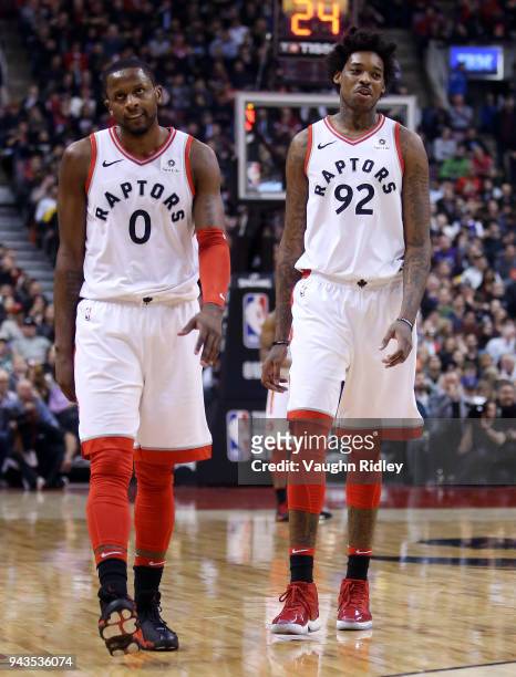 Lucas Nogueira of the Toronto Raptors commiserates with C.J. Miles after a missed shot during the first half of an NBA game against the Boston...