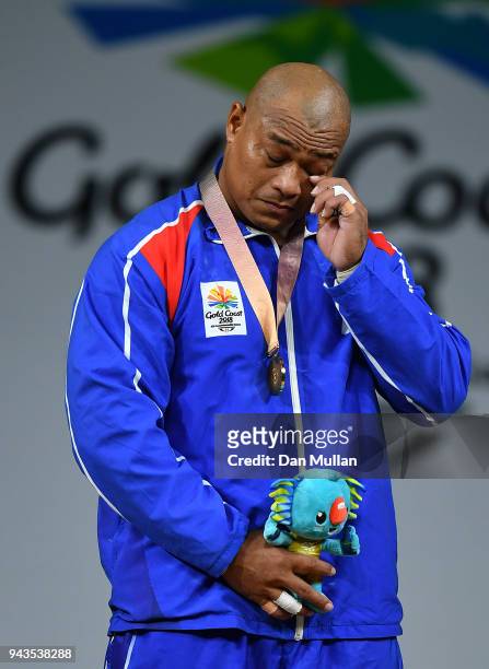 Sanele Mao of Samoa sheds a tear on the podium as he poses with the gold medal for Men's 105kg Final during the Weightlifting on day five of the Gold...
