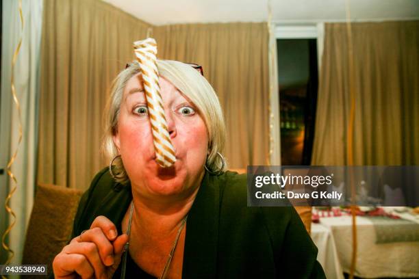 woman celebrating with party blower - roltong stockfoto's en -beelden