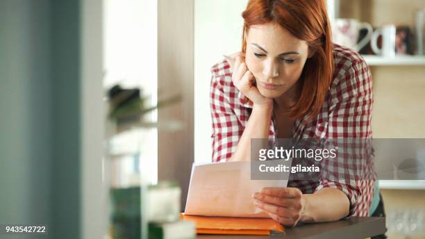 hoge kosten van levensonderhoud - woman filling out paperwork stockfoto's en -beelden