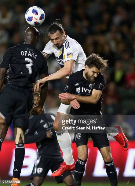 Zlatan Ibrahimovic of Los Angeles Galaxy heads the ball over the defense of Ike Opara and Graham Zusi of Sporting Kansas City during the second half...