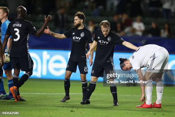 Graham Zusi, Seth Sinovic, and Ike Opara of Sporting Kansas City celebrate as Zlatan Ibrahimovic of Los Angeles Galaxy looks on after a game at...