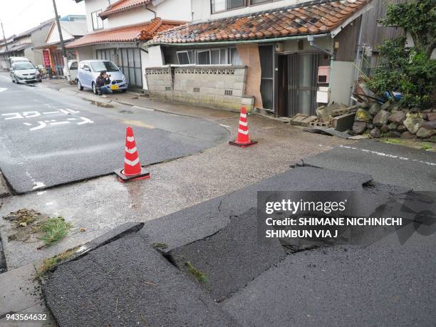 This photo released by the Shimane Nichinichi Shimbun via Jiji Press on April 9, 2018 shows the tarmac along a street damaged by a earthquake in the...