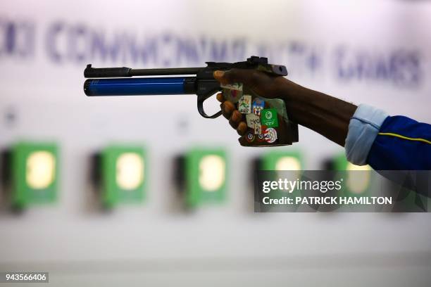 Bernard Chase of Barbados aims his pistol as he takes part in the 10m air pistol men's qualification shooting final during the 2018 Gold Coast...