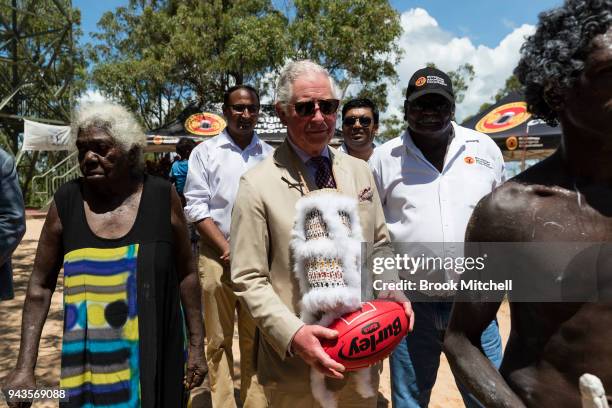 Prince Charles, Prince of Wales clutches an Australian Rules Football gifted to him after a Welcome to Country Ceremony on April 9, 2018 in Gove,...