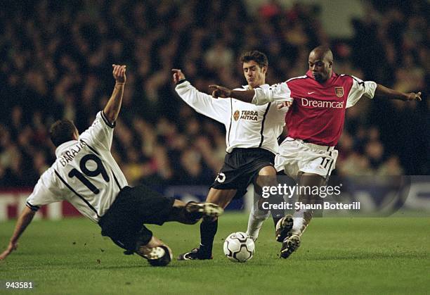 Sylvain Wiltord of Arsenal is foiled by Ruben Baraja and Pablo Aimar of Valencia during the UEFA Champions League Quarter Finals first leg match...