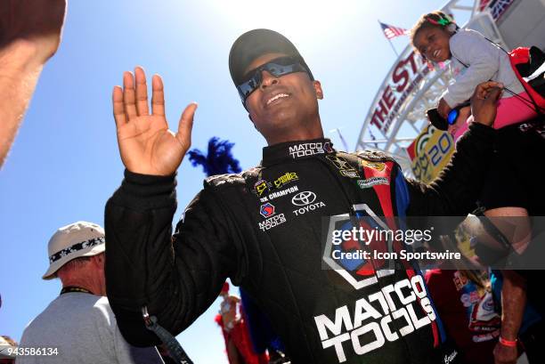 Antron Brown Don Schumacher Racing NHRA Top Fuel Dragster high-fives fans during pre-race festivities for the NHRA Denso Spark Plugs Four Wide...