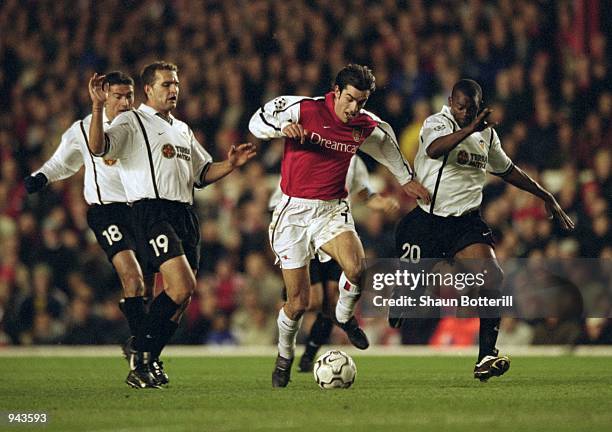 Robert Pires of Arsenal takes on Ruben Baraja and Jocelyn Angloma of Valencia during the UEFA Champions League Quarter Finals first leg match played...