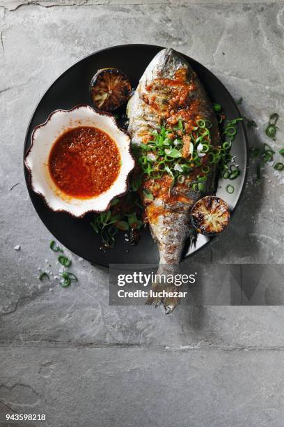 barbecued whole snapper with sauce - grilled fish stock pictures, royalty-free photos & images