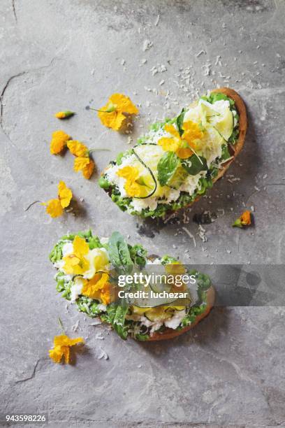 bruschetta con zucchini a la parrilla, chícharos y queso mozzarella, ricotta y menta - comida flores fotografías e imágenes de stock