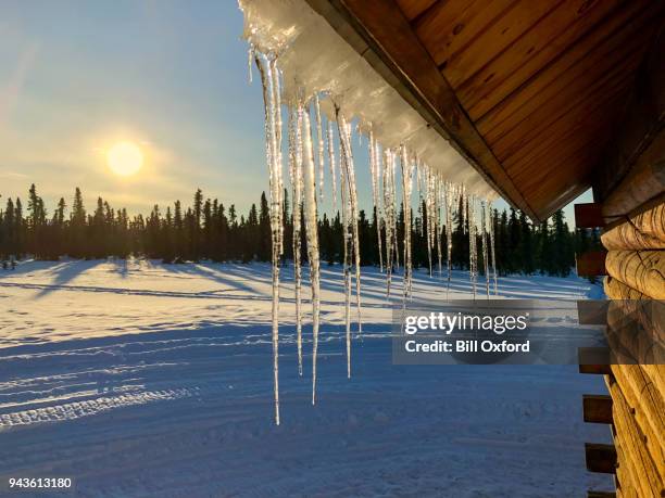 glaçons sur le toit et le coucher du soleil - icicle photos et images de collection