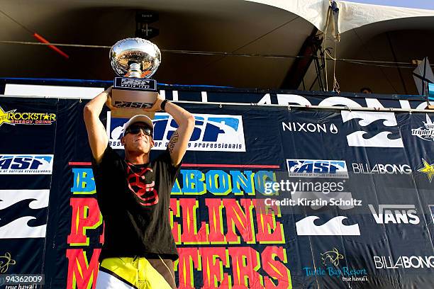 Mick Fanning of Australia hoists his ASP World Title trophy after winning his second ASP World Title at the Billabong Pipeline Masters on December...