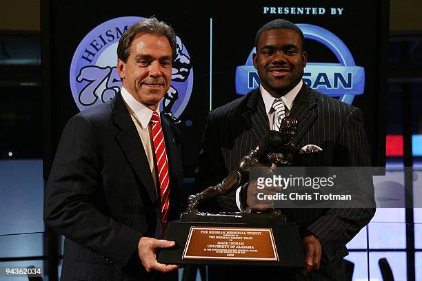 Running back Mark Ingram of the Alabama Crimson Tide poses with Head coach Nick Saban and the Heisman Trophy during a press conference after being...
