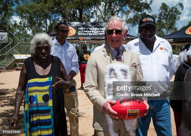 Prince Charles, Prince of Wales clutches an Australian Rules Football gifted to him after a Welcome to Country Ceremony on April 9, 2018 in Gove,...