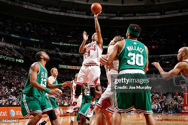 Derrick Rose of the Chicago Bulls goes to the basket over Shelden Williams and Rasheed Wallace of the Boston Celtics during the NBA game on December...