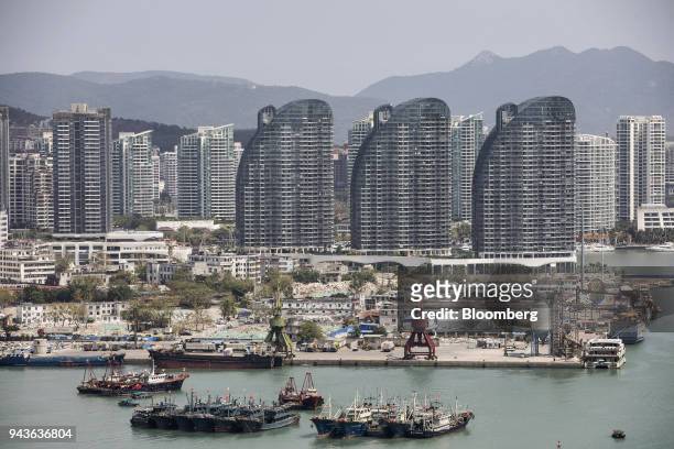 Fishing boats are anchored in the harbor as buildings stand in Sanya, Hainan province, China, on Tuesday, March 13, 2018. Chinese President Xi...