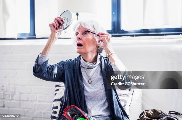 senior vrouw klaar voor haar dagje uit - 70s eye makeup stockfoto's en -beelden