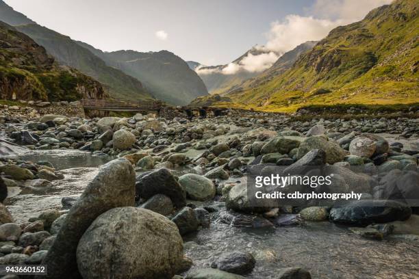 río que fluye a través de los alpes suizos, sunrise - roca fotografías e imágenes de stock
