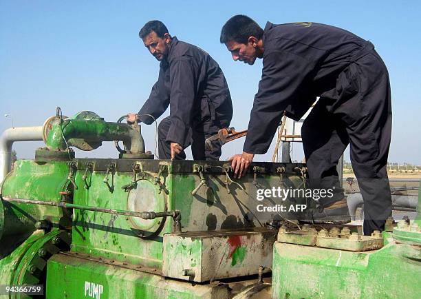 Iraqi labourers work at the Halfaya oil field near the southern city of Amara in Iraq's southern Maysan province on December 12, 2009. Asian firms...