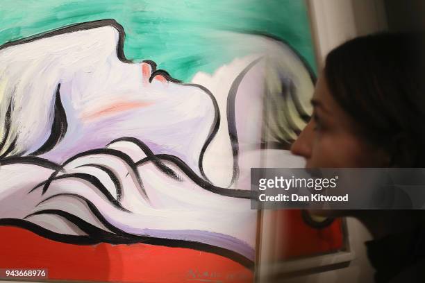 Sotheby's employee poses next to a painting by Pablo Picasso entitled 'Le Repos' 1932, during a UK preview of the 'Impressionist and Modern Art' sale...