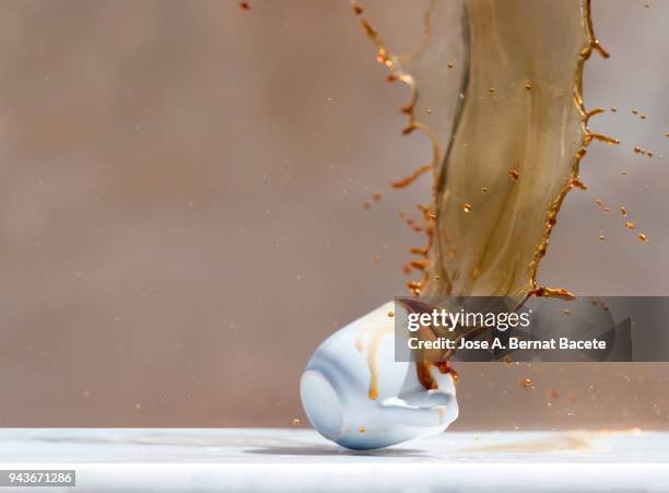 impact of a coffee cup that falls down on the soil. - broken cup stock-fotos und bilder