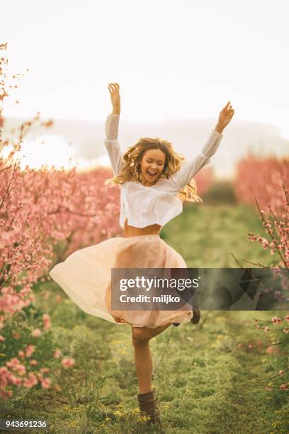 schöne junge frau mit kirschblüte im frühling - fashion woman jumping stock-fotos und bilder