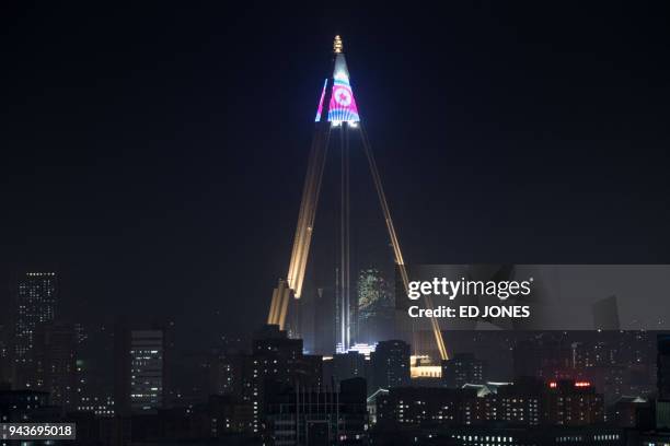 Light show displays a North Korean flag atop the Ryugyong hotel above the city skyline of Pyongyang on April 9, 2018.