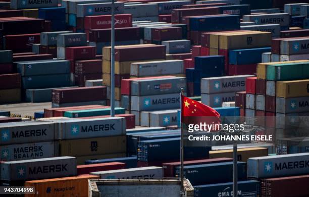 Chinese flag is seen in front of containers at the Yangshan Deep-Water Port, an automated cargo wharf, in Shanghai on April 9, 2018. - China warned...