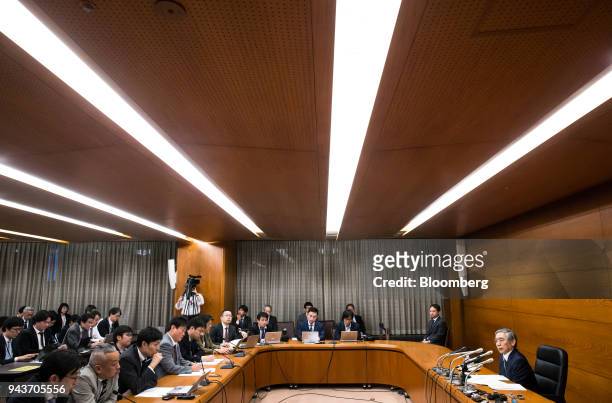 Haruhiko Kuroda, governor of the Bank of Japan , right, speaks during a news conference at the central bank's headquarters in Tokyo, Japan, on...
