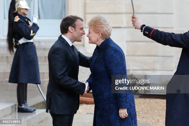 French President Emmanuel Macron welcomes Lituania president Dalia Grybauskaite before a meeting at the Elysee palace on April 9, 2018 in Paris. /...