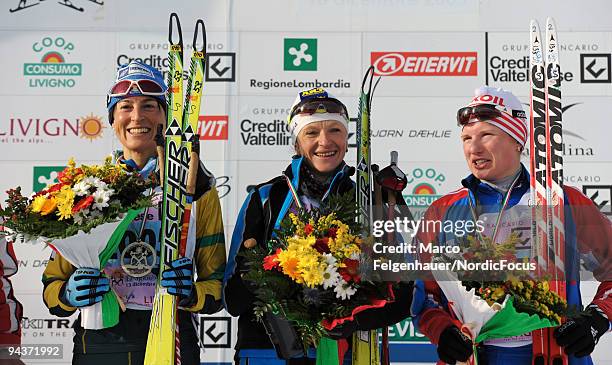 Antonella Confortola of Italy, Valentina Shevchenko of Ukraine and Yulia Tchekaleva of Russia pose at the flower ceremony after the FIS Cross Country...