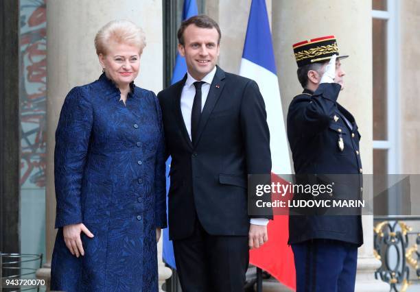 French President Emmanuel Macron welcomes Lituania president Dalia Grybauskaite before a meeting at the Elysee palace on April 9, 2018 in Paris. /...