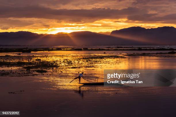 fisherman in myanmar at sunset - ignatius tan stock-fotos und bilder