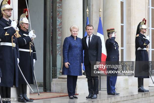 French President Emmanuel Macron welcomes Lituania President Dalia Grybauskaite before a meeting at the Elysee palace on April 9, 2018 in Paris. /...
