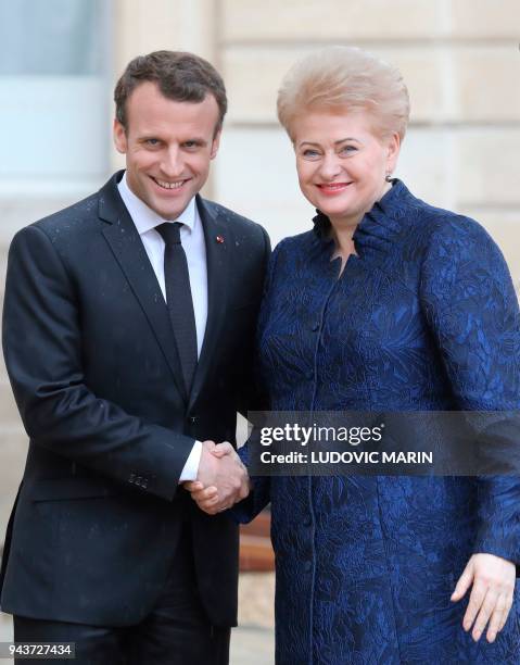 French President Emmanuel Macron welcomes Lituania President Dalia Grybauskaite before a meeting at the Elysee palace on April 9, 2018 in Paris. /...