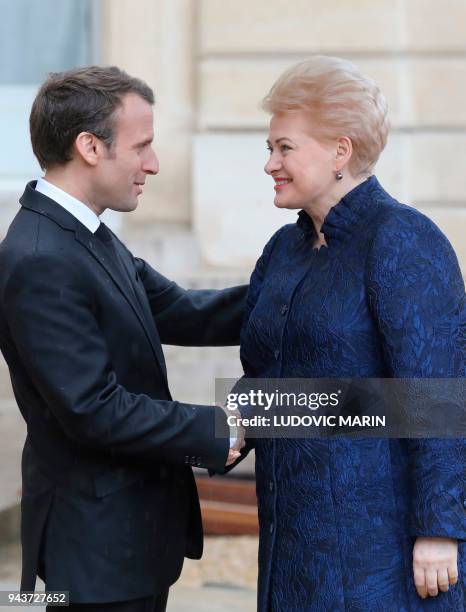 French President Emmanuel Macron welcomes Lituania President Dalia Grybauskaite before a meeting at the Elysee palace on April 9, 2018 in Paris. /...