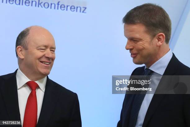 Christian Sewing, management board member of Deutsche Bank AG, right, and John Cryan, chief executive officer of Deutsche Bank AG, react during the...