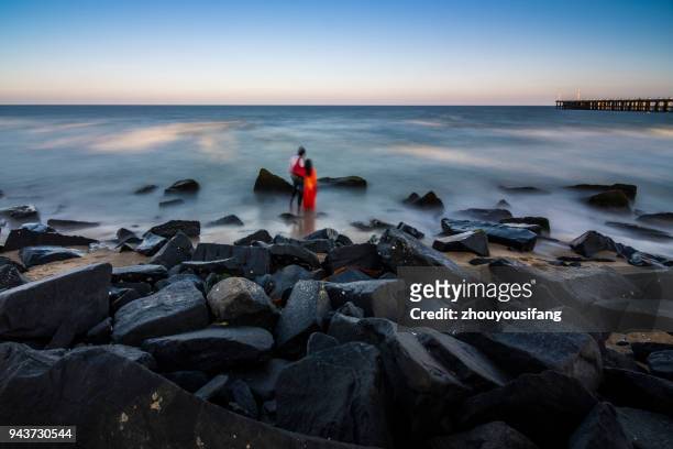 a pair of lovers stood on the beach and watched the sea - pondicherry stock pictures, royalty-free photos & images