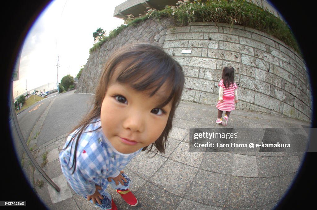A girl looking at fish-eye lens camera in Japan