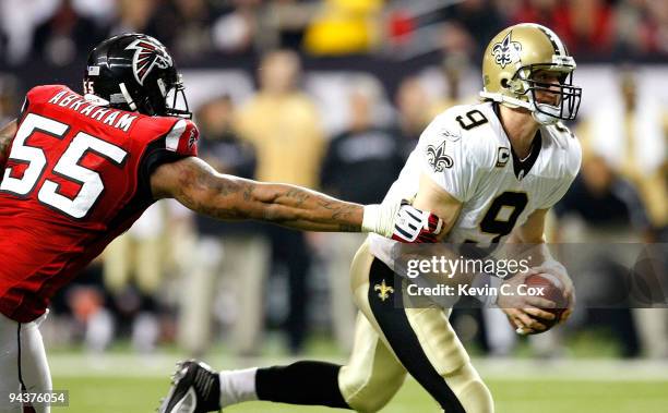 John Abraham of the Atlanta Falcons pressures quarterback Drew Brees of the New Orleans Saints at Georgia Dome on December 13, 2009 in Atlanta,...