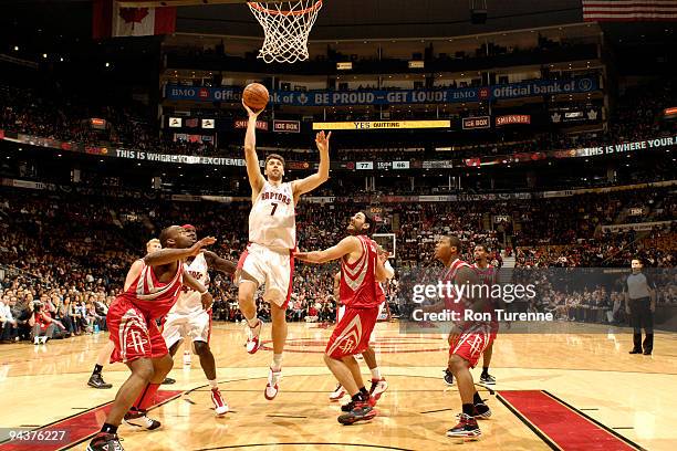 Andrea Bargnani of the Toronto Raptors drives the lane and looks to sink the one-handed jumper next to Luis Scola of the Houston Rockets during a...