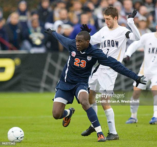 Tony Tchani of the Virginia Cavaliers looks to play the ball while being defended by Blair Gavin of the Akron Zips during first half action of the...