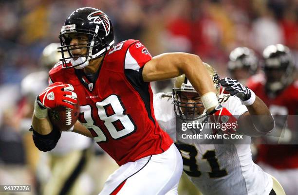 Tony Gonzalez of the Atlanta Falcons runs for yards after the catch against Will Smith of the New Orleans Saints at Georgia Dome on December 13, 2009...