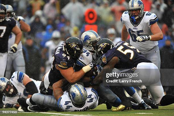 Kevin Smith of the Detroit Lions is tackled by Terrell Suggs and Justin Bannan of the Baltimore Ravens at M&T Bank Stadium on December 13, 2009 in...